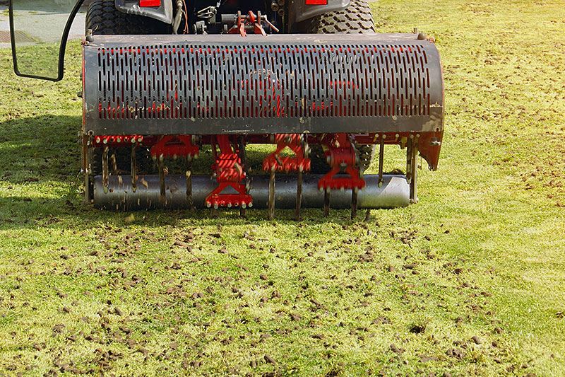 Aeration machine removing soil plugs from lawn